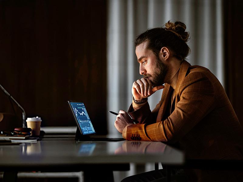 Mand der kigger på tablet og investeringer